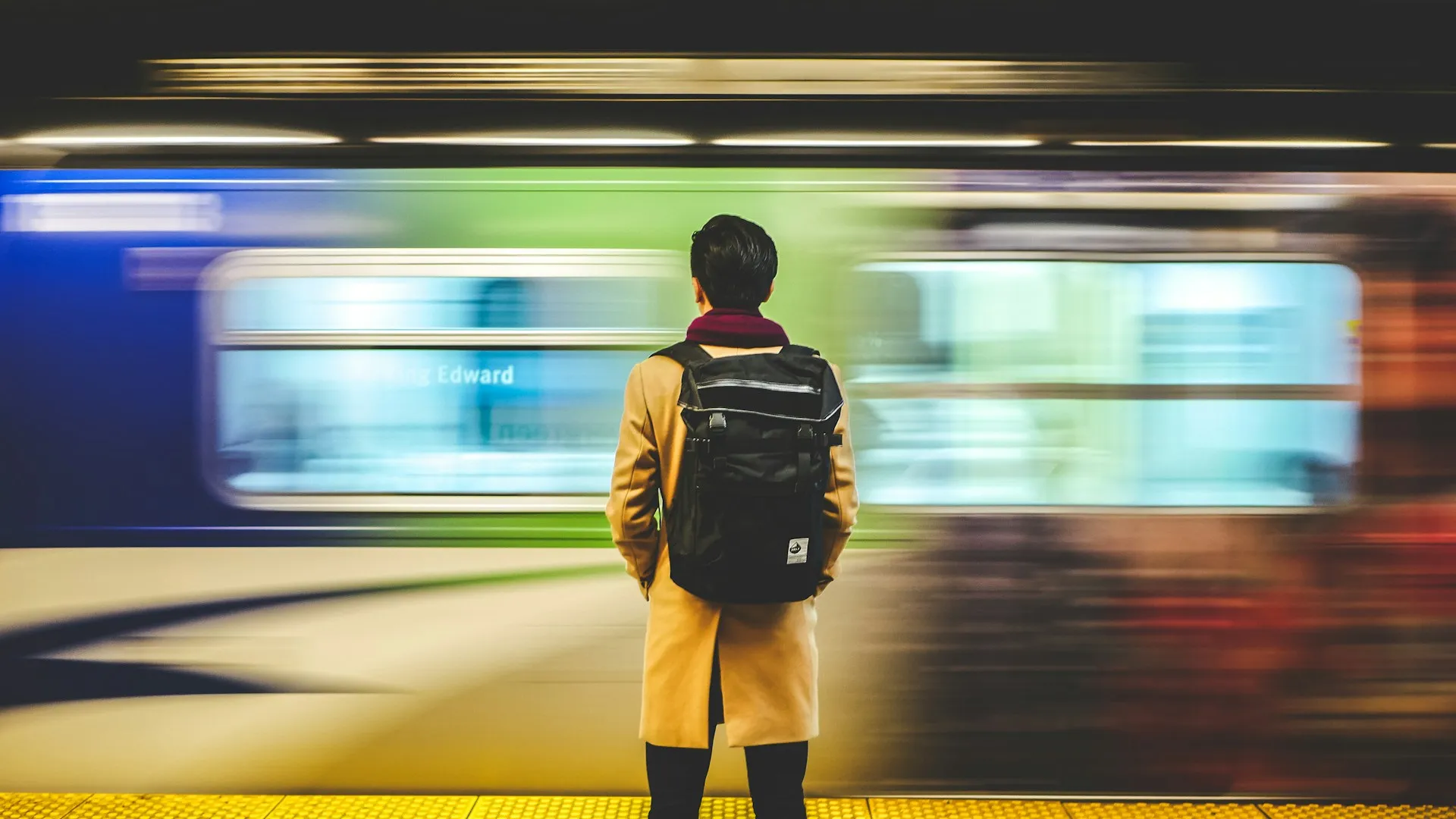 A traveler arriving with a rolling suitcase at sunset